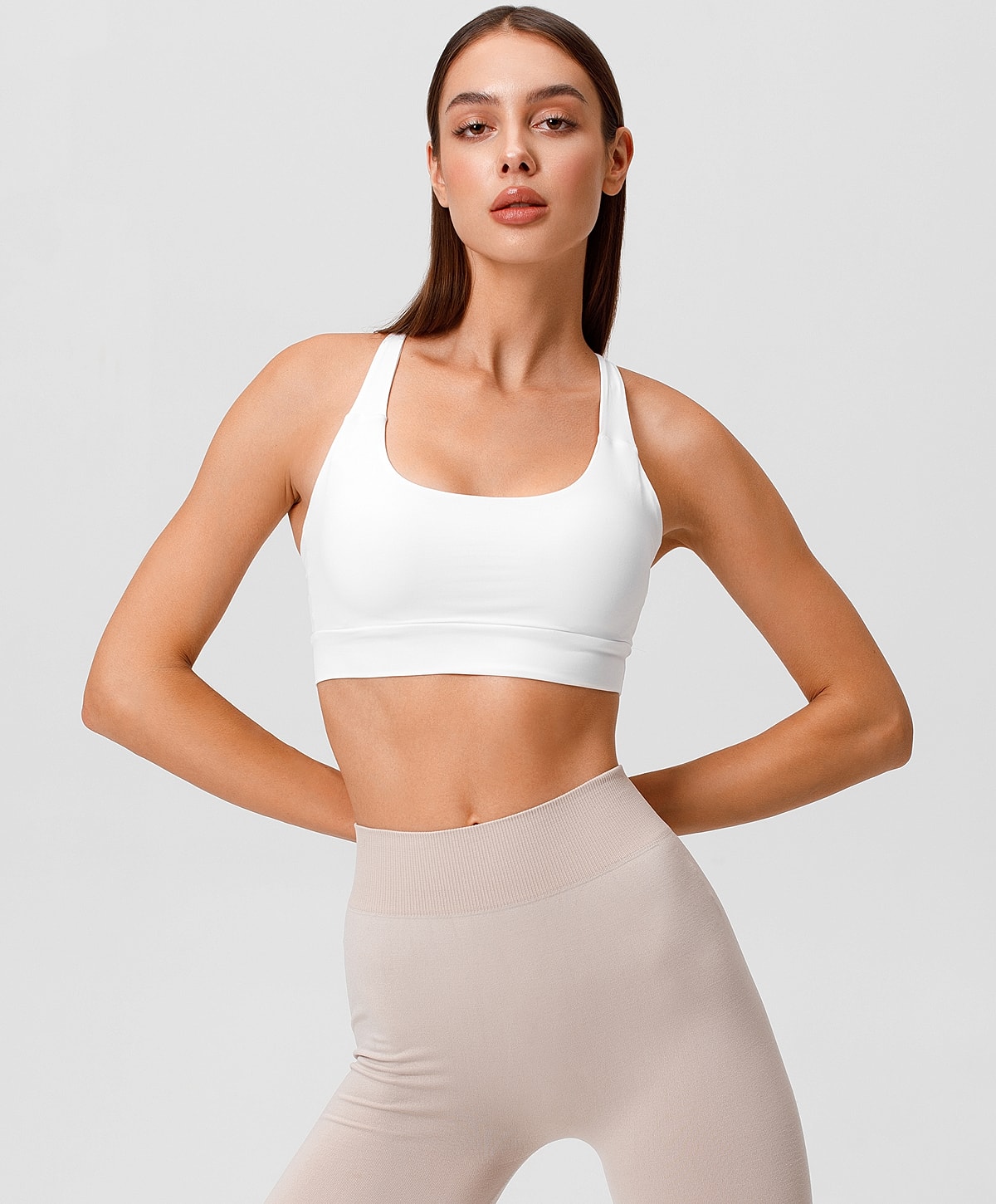 Charlotte, NC liposuction model in white sports bra and leggings.