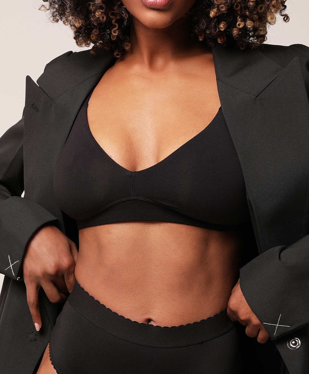 Charlotte, NC breast implant exchange model wearing black lingerie and oversized blazer.