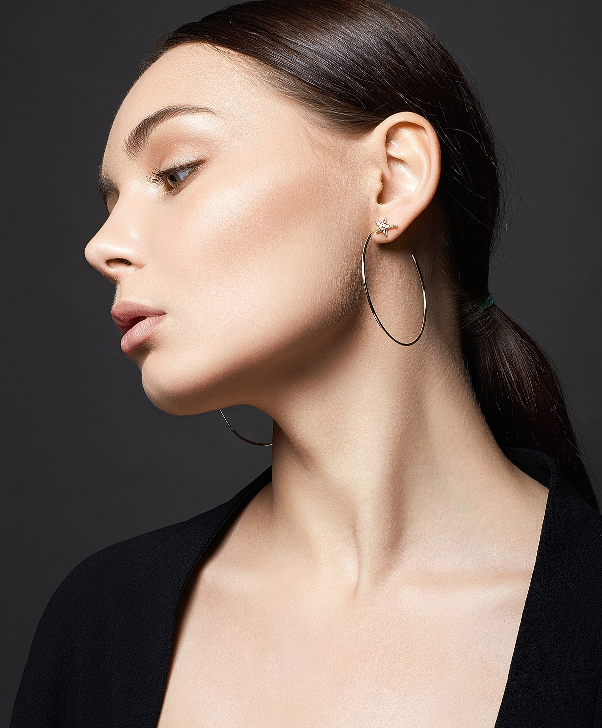 Charlotte, NC earlobe repair model showcasing earrings and sleek hairstyle.