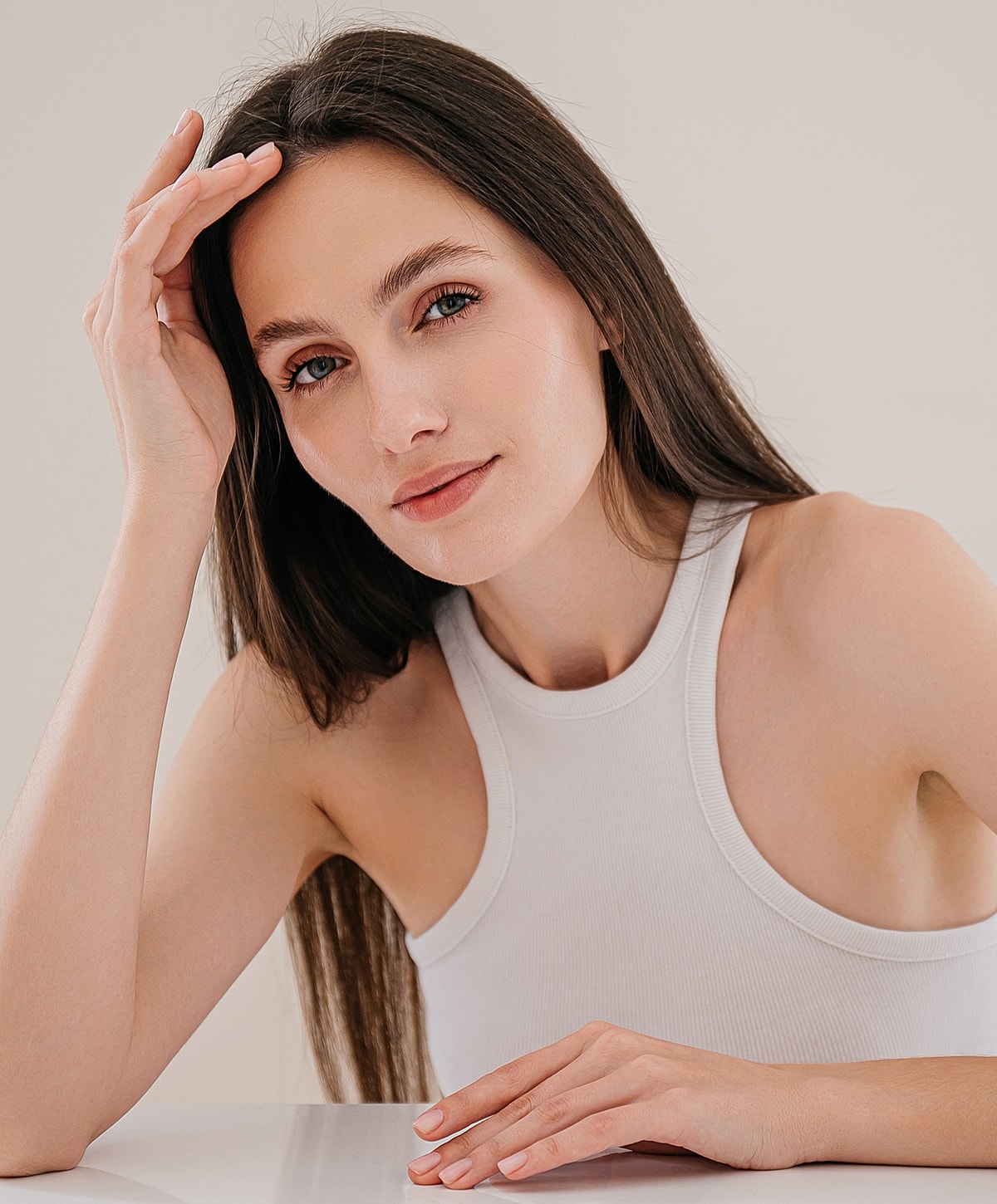 Charlotte, NC blepharoplasty model with long hair in a white tank top.