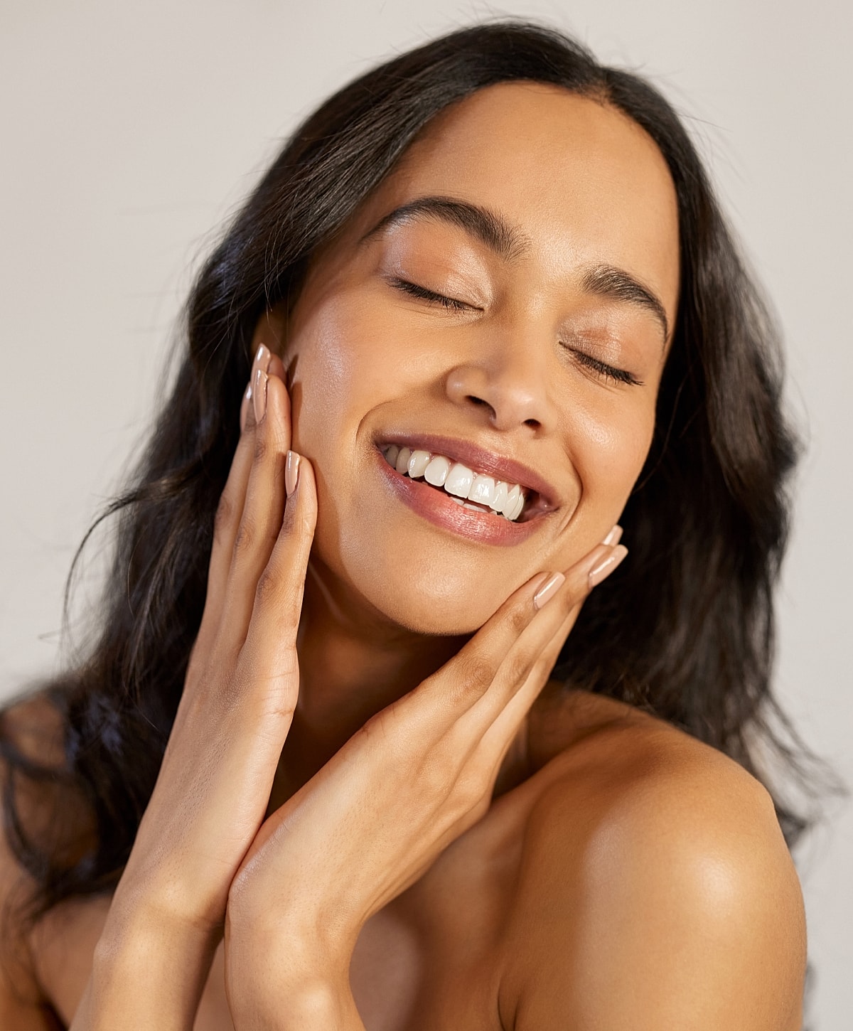 Charlotte, NC facelift model touching her face, glowing skin.