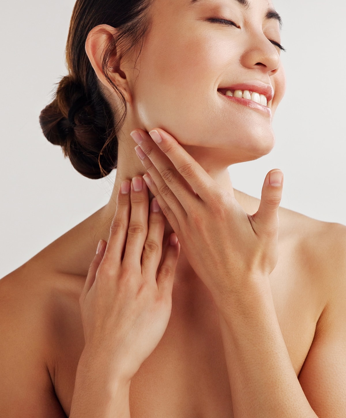 Charlotte, NC IPL Laser model gently touching her neck and smiling.