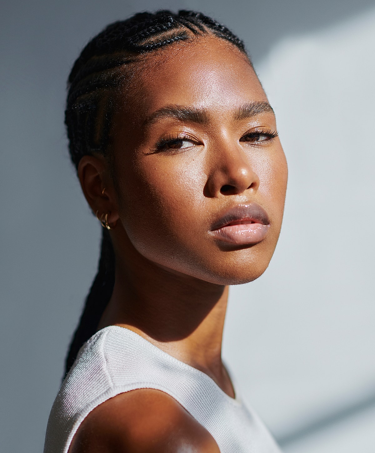 Charlotte, NC RF Microneedling model with braided hair in soft lighting.