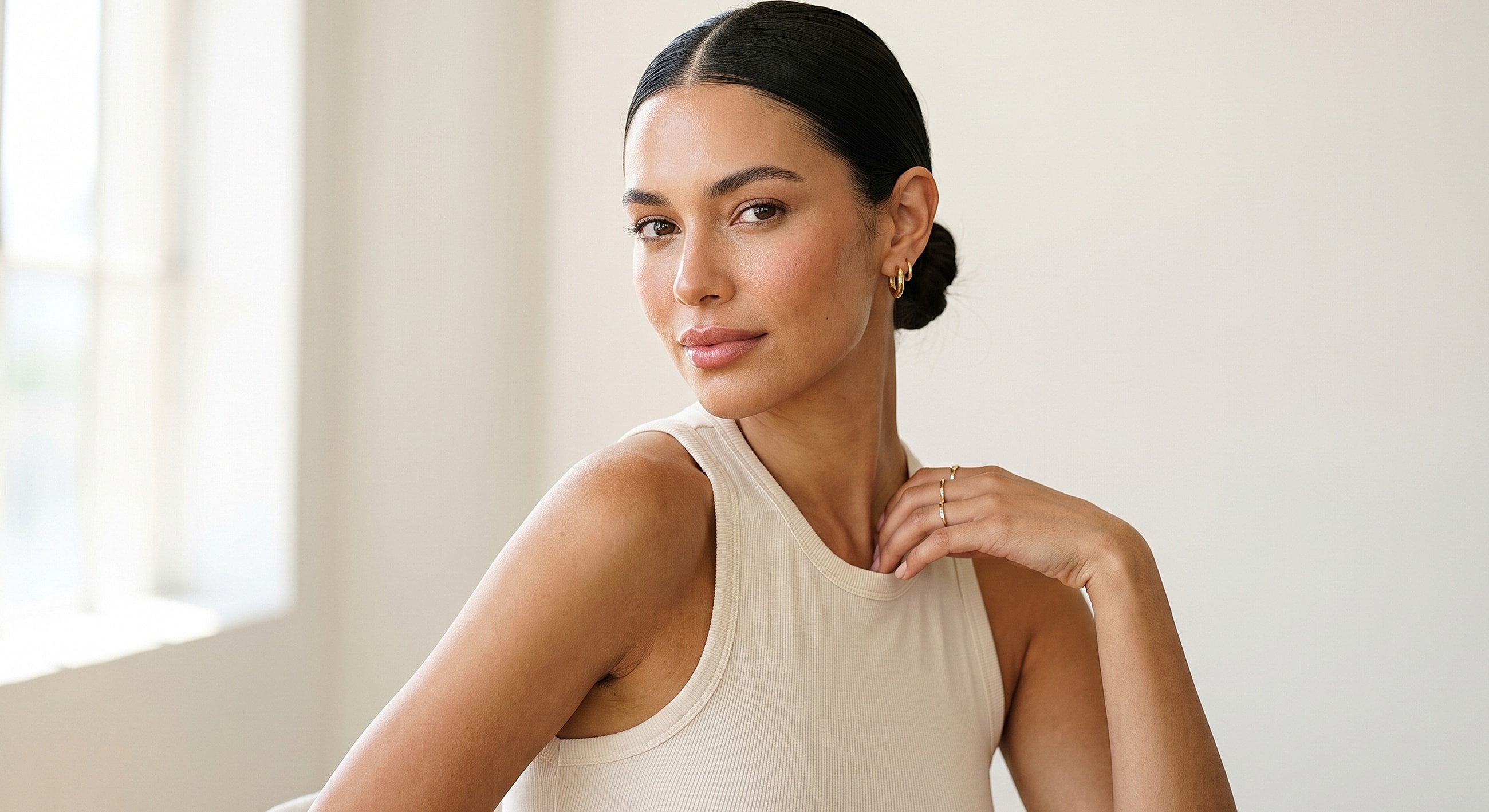 Smiling woman with sleek hair in neutral attire.